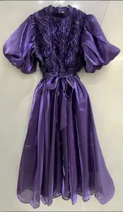 Vista detallada de un elegante vestido morado con mangas abullonadas y corpiño texturizado.