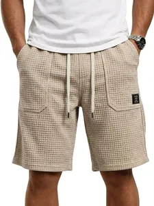 Detail der Textur von beigen Waffel-Strick-Herrenshorts mit Kordelzug und Taschenetikett