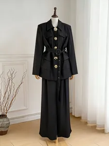 Detailed full view of an elegant black suit set with decorative gold flower buttons.