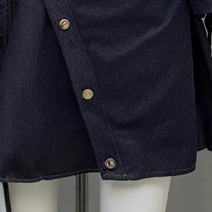 Detail of elegant dark blue denim wrap dress with vintage gold-tone button accents.