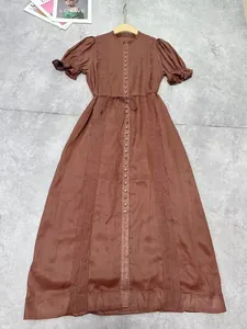 Gros plan sur les broderies et les boutons d'une robe mi-longue marron de style japonais