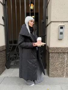 Stylish women's long black puffer coat styled with a grey beanie and wide-leg trousers