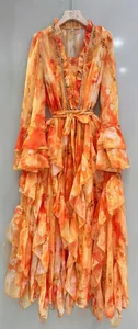 Close-up of floral maxi dress featuring rhinestone V-neck and ruffled layered hemline.