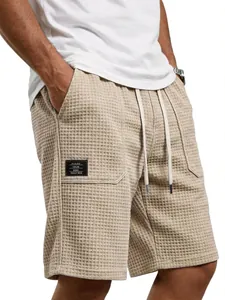 Detailansicht der beigen Herren-Shorts mit Waffelstruktur, Kordelzug und aufgesetzter Tasche