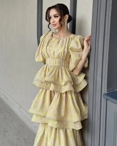 Detailed look at a yellow floral pleated tiered ruffle dress featuring stylish puff sleeves