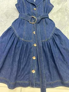 Dettaglio di un abito in denim senza maniche con cintura in vita e bottoni
