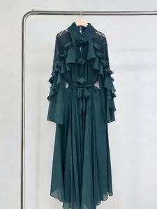 Detail shot of an elegant dark green maxi dress with layered ruffles and lace sleeves.