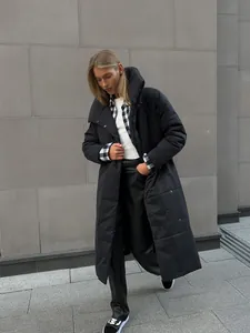 Full length photo of a woman wearing a stylish long black oversized puffer coat outdoors