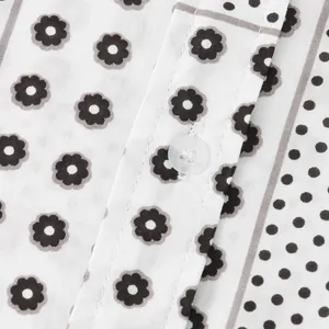 Detail view of white floral patterned men's shirt with button and fine stitching