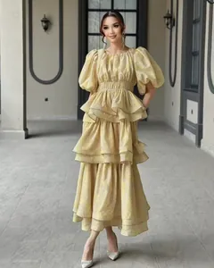 Full-length editorial shot of the layered ruffle dress in an architectural hallway setting