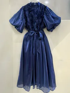 Elegante vestido largo de satén azul con mangas abullonadas, volantes y cinturón