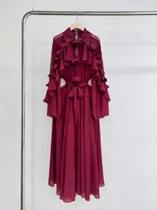Elegant burgundy long-sleeve maxi dress with layered ruffles and lace details on hanger