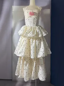 Elegante witte polka dot halterjurk met gelaagde rok en roze bloemdetail voor dames