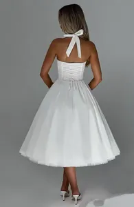 Back view of white halter neck dress with lace-up corset and flared tulle skirt.