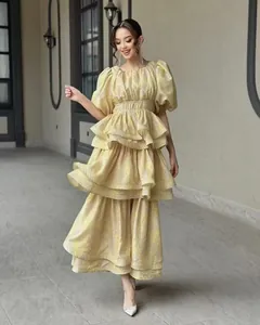 Elegant tiered ruffle maxi dress with puff sleeves and yellow floral pattern