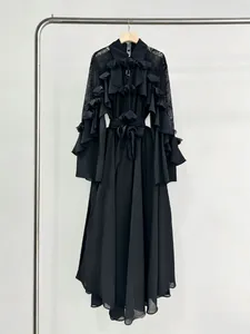 Detailed view of an elegant black long-sleeve dress with ruffles and lace sleeves.