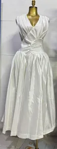 Elegante witte mouwloze maxi-jurk met plooien, een slanke taille en luxe satijnen afwerking