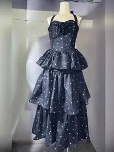 Elegante zwarte polkadots jurk met halster en gelaagde ruches details
