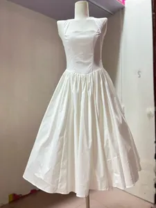 Front detail view of a white halter-neck midi dress with pleated skirt on mannequin