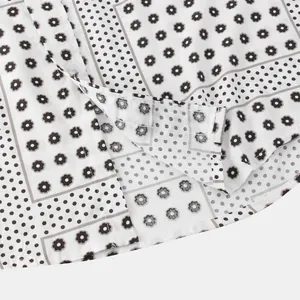 Macro view of men's casual shirt featuring a floral and polka dot patchwork pattern