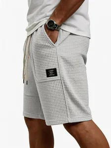 Detailansicht der hellgrauen Waffelstruktur und des Patches an der Herrenshorts