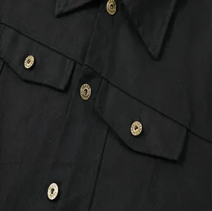 Primer plano de los botones metálicos y detalles de bolsillos en chaqueta vaquera negra