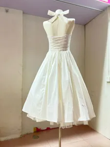 Detailed back view of a white halter dress featuring a lace-up corset bodice.
