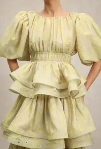 Close-up detail of a light floral tiered ruffle dress with puff sleeves and smocked waist.