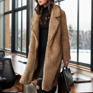 Detail view of a long camel teddy coat styled with black outfit in a cozy office setting