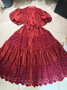 Close-up of wine red lace hollow-out embroidery on a French palace style maxi dress