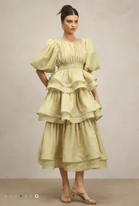 Pale yellow tiered ruffle midi dress with puff sleeves and subtle floral patterns.