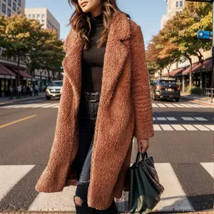 Model wearing a stylish brown plush teddy coat walking across a sunlit urban city street