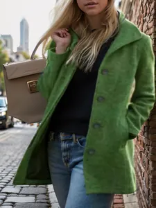 Detailed view of women's vintage green wool coat with textured fabric in street style setting