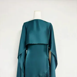 Close-up detail of teal acetate satin dress featuring a matching shawl and elegant drape.