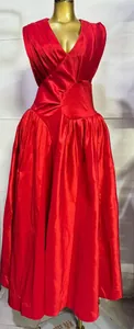Gedetailleerd zicht op een elegante rode maxi-jurk met geplooide ruches en een V-hals.