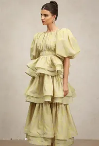 Elegant detail view of a yellow floral tiered maxi dress with large puff sleeves.