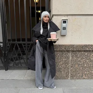 Stylish women's long black puffer coat in street fashion style with warm quilted finish.