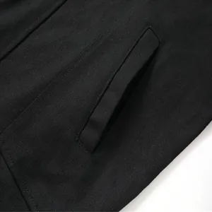 Primer plano del bolsillo lateral y la textura de la tela de la chaqueta de trabajo negra