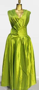 Detailed view of the elegant lime green pleated French style long dress on a mannequin