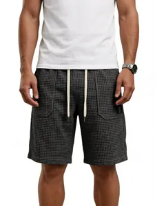 Detailansicht der dunkelgrauen Waffelstrick-Shorts mit weißem Kordelzug und Tasche