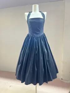 Detailed shot of a stylish black pleated halter neck midi dress on a mannequin.