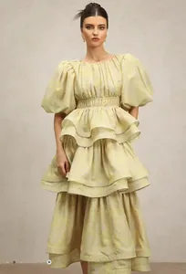 Detailed view of pale yellow tiered ruffle dress with puff sleeves and smocked waist