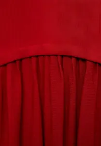 Gros plan détaillé sur la texture élégante du tissu plissé rouge d'une robe chic.