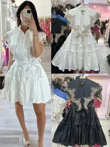 Detailed view of ruffle tiered mini dress featuring intricate floral embroidery on collar
