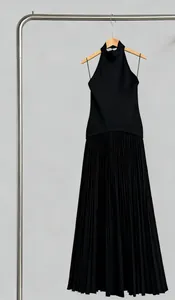 Vue détaillée d'une élégante robe longue noire à licou avec jupe plissée sur cintre