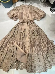 Detail of French lace patchwork embroidered dress with waist tie and puff sleeves