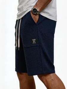 Nahaufnahme von lässigen Herren-Shorts mit Waffelstruktur und 'Classic Wear'-Aufnäher.