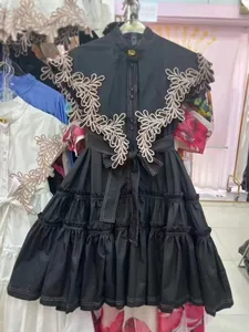 Elegant black A-line tiered dress featuring floral embroidery and a bow waist tie