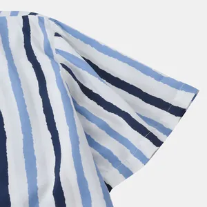 Gros plan sur la manche d'une chemise à rayures bleues et blanches, tissu