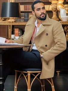 Elegant men's mid-length camel wool coat in a classic British style library setting.